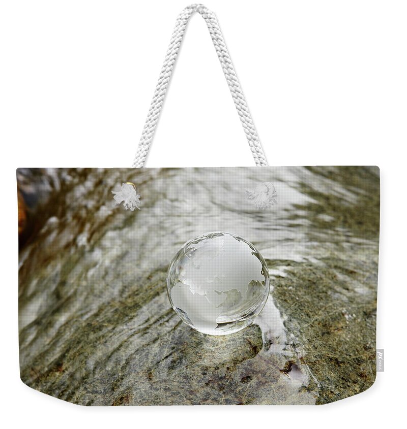 Environmental Conservation Weekender Tote Bag featuring the photograph Glass Globe On The Water Stream by Sot