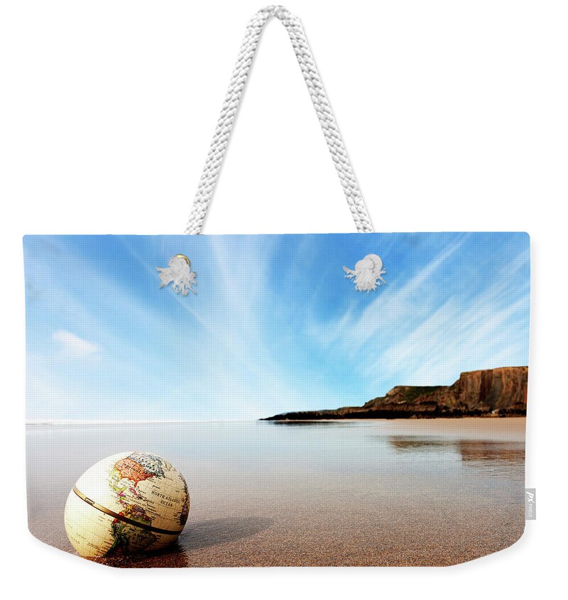 Water's Edge Weekender Tote Bag featuring the photograph Globe On The Beach by Urbancow