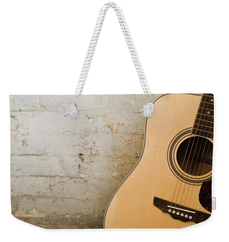 Music Weekender Tote Bag featuring the photograph Guitar And Brick Wall by Jupiterimages