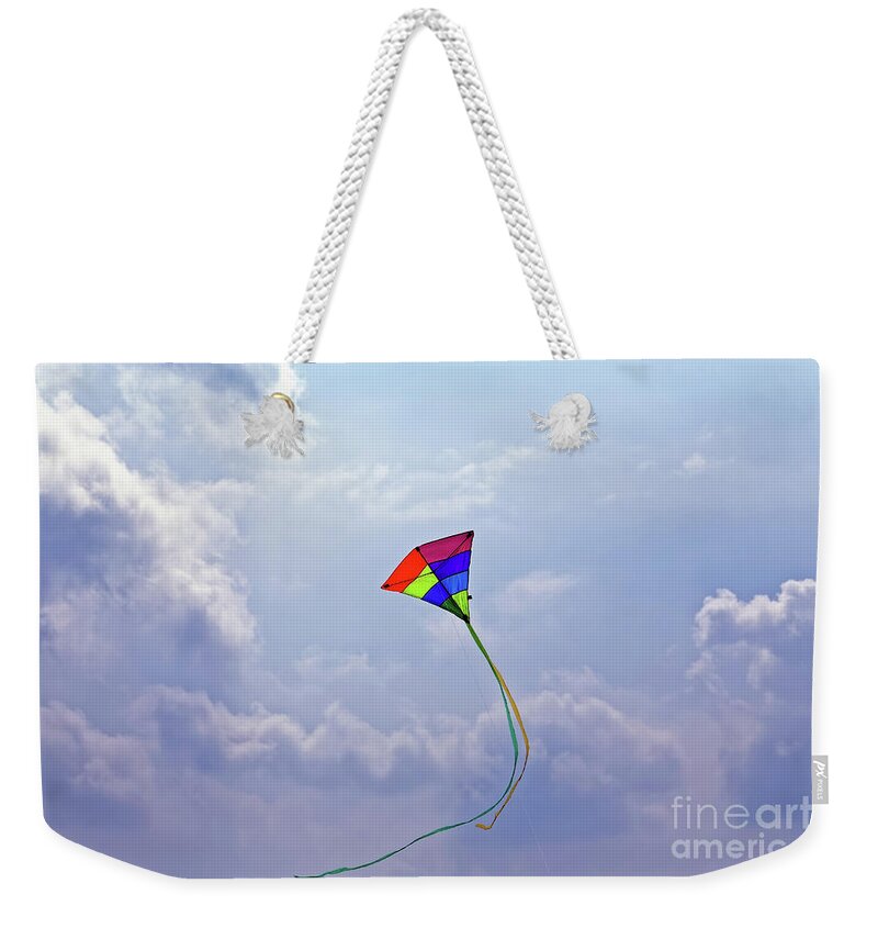 High Flying Swirling Kite Weekender Tote Bag featuring the photograph High Flying Multicolored Red Yellow Green Blue Purple Triangular Kite Flying Sunny Cloudy Blue Sky by Robert C Paulson Jr