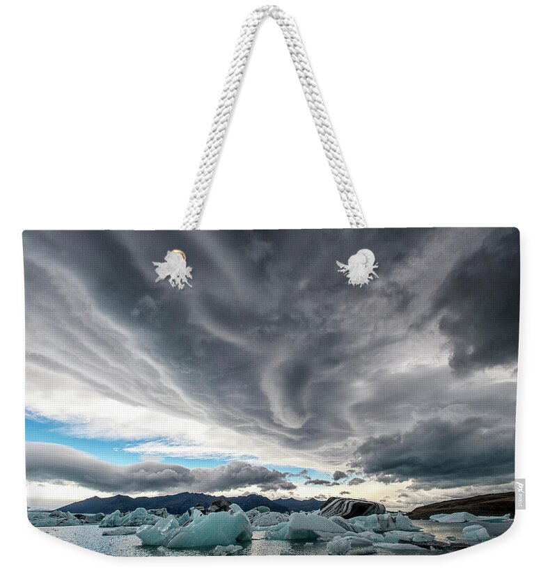 Cold Temperature Weekender Tote Bag featuring the photograph Icebergs In Glacial Lagoon With Stormy by Mike Hill