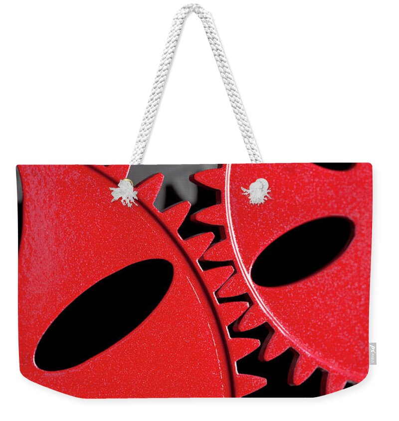 Teamwork Weekender Tote Bag featuring the photograph Interlocking Red Cogs by Nicholas Rigg