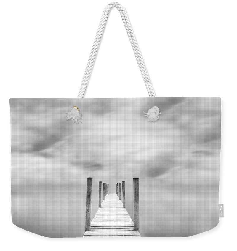 Tranquility Weekender Tote Bag featuring the photograph Jetty Against Cloudy Sky by Doug Chinnery