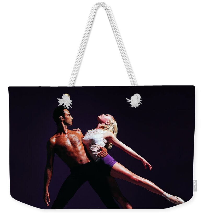 Young Men Weekender Tote Bag featuring the photograph Male Ballet Dancer Holding Female Dancer by Chris Nash