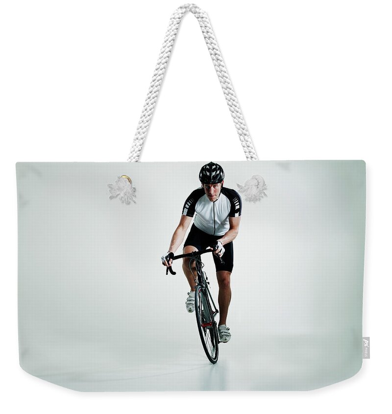 People Weekender Tote Bag featuring the photograph Male Cyclist Standing In Pedals Riding by Thomas Barwick