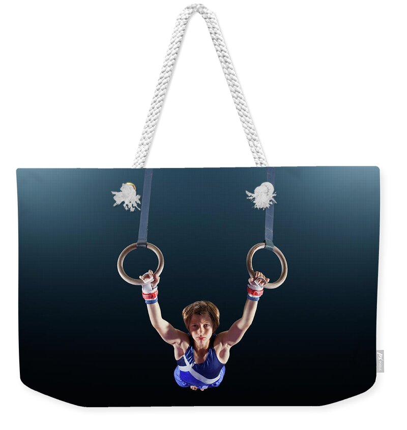 Focus Weekender Tote Bag featuring the photograph Male Gymnast Performing On Rings by Robert Decelis Ltd