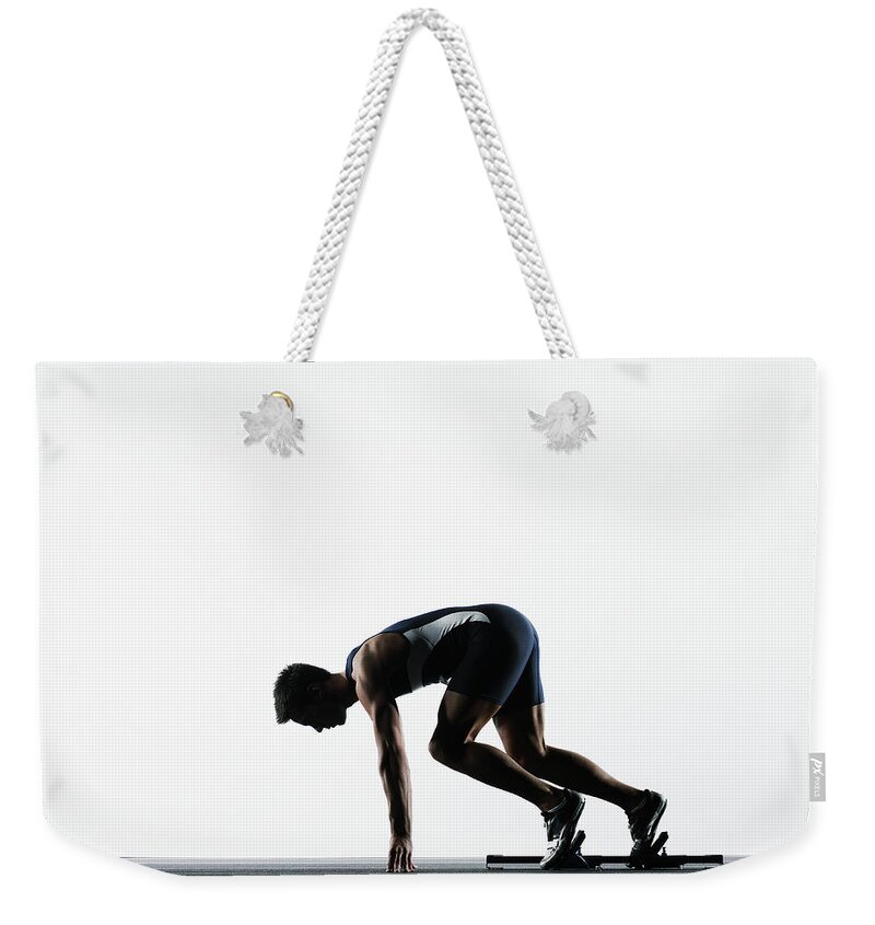 Shadow Weekender Tote Bag featuring the photograph Male Runner In Starting Block by Thomas Barwick