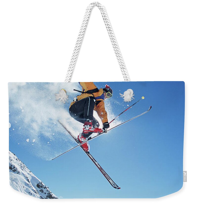 Skiing Weekender Tote Bag featuring the photograph Male Skier In Mid-air, Low Angle View by Jakob Helbig