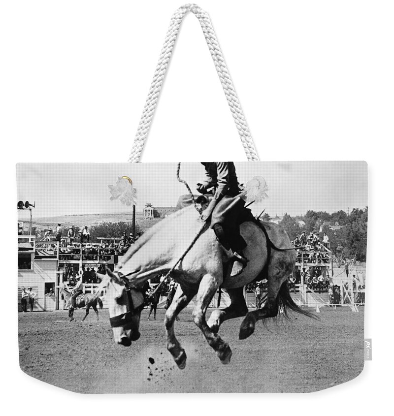 Horse Weekender Tote Bag featuring the photograph Man Riding Bucking Horse In Rodeo by Stockbyte