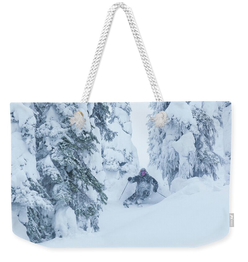 Ski Pole Weekender Tote Bag featuring the photograph Man Skiing Through Trees On Snowy Day by Noah Clayton