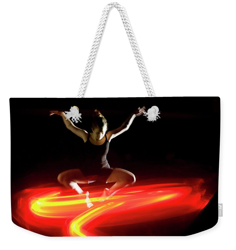 Ballet Dancer Weekender Tote Bag featuring the photograph Modern Dancer Leaping Above Orange by John Rensten