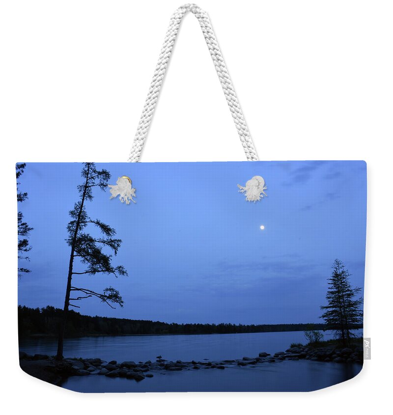 U.s. Army Corps Of Engineers Weekender Tote Bag featuring the photograph Moon rises above the trees at the Mississippi River Headwaters by Boyd Carter