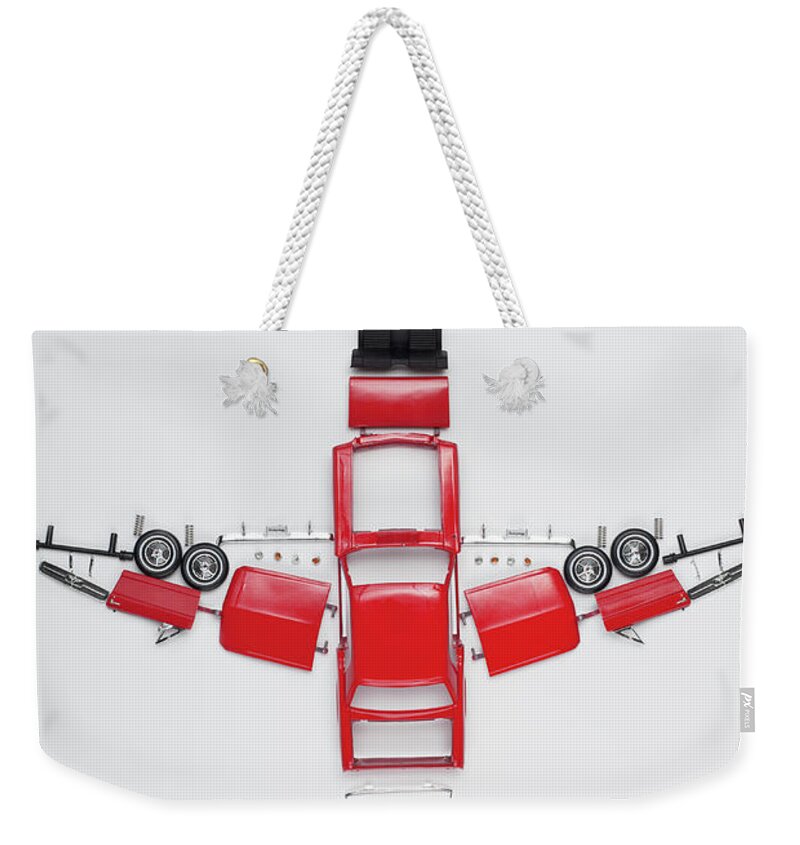 White Background Weekender Tote Bag featuring the photograph Parts Of A Model Car Arranged In The by Larry Washburn