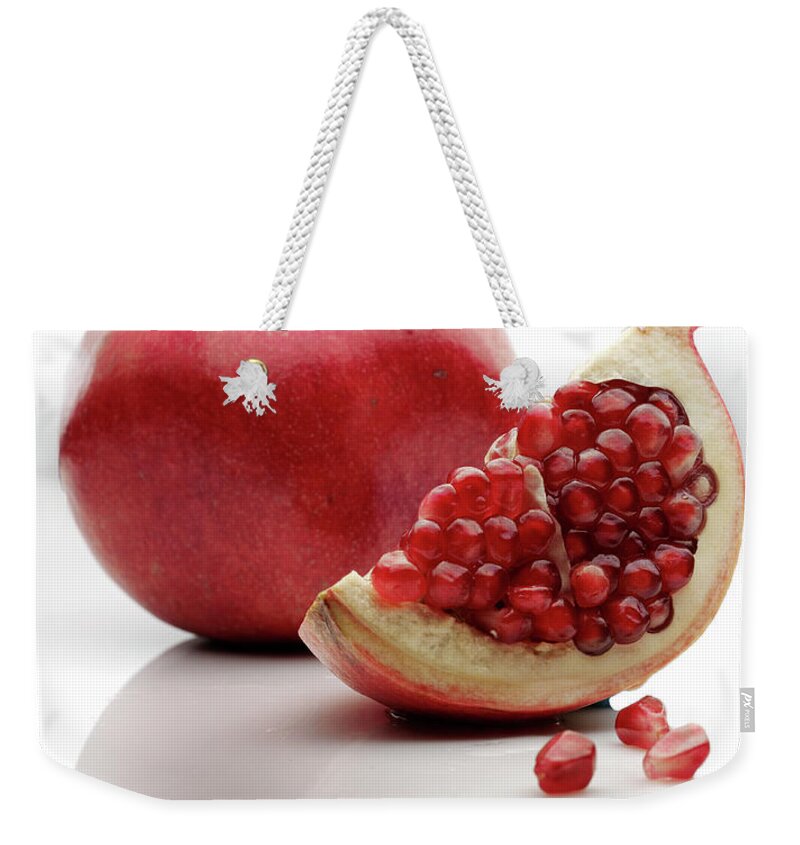 White Background Weekender Tote Bag featuring the photograph Pomegranate, With Slice, On White by Howard Bjornson