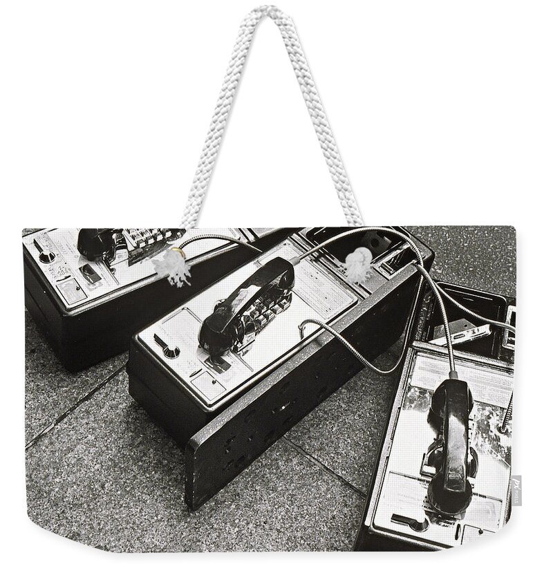 Telephone Weekender Tote Bag featuring the photograph Public Phones Lying On Sidewalk by Henri Silberman