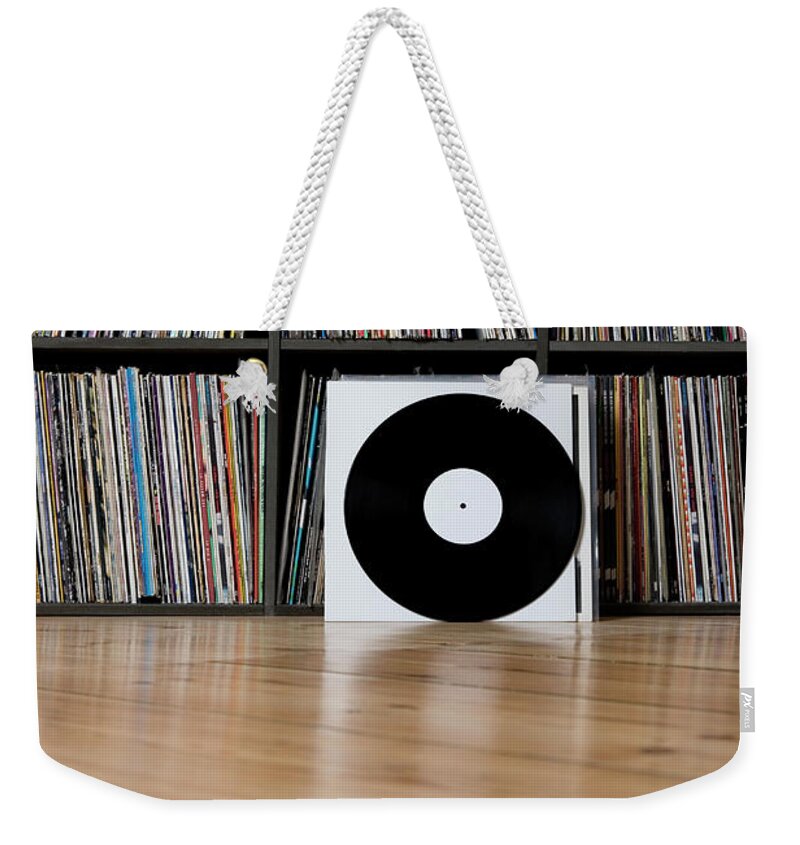 Music Weekender Tote Bag featuring the photograph Records Leaning Against Shelves by Halfdark