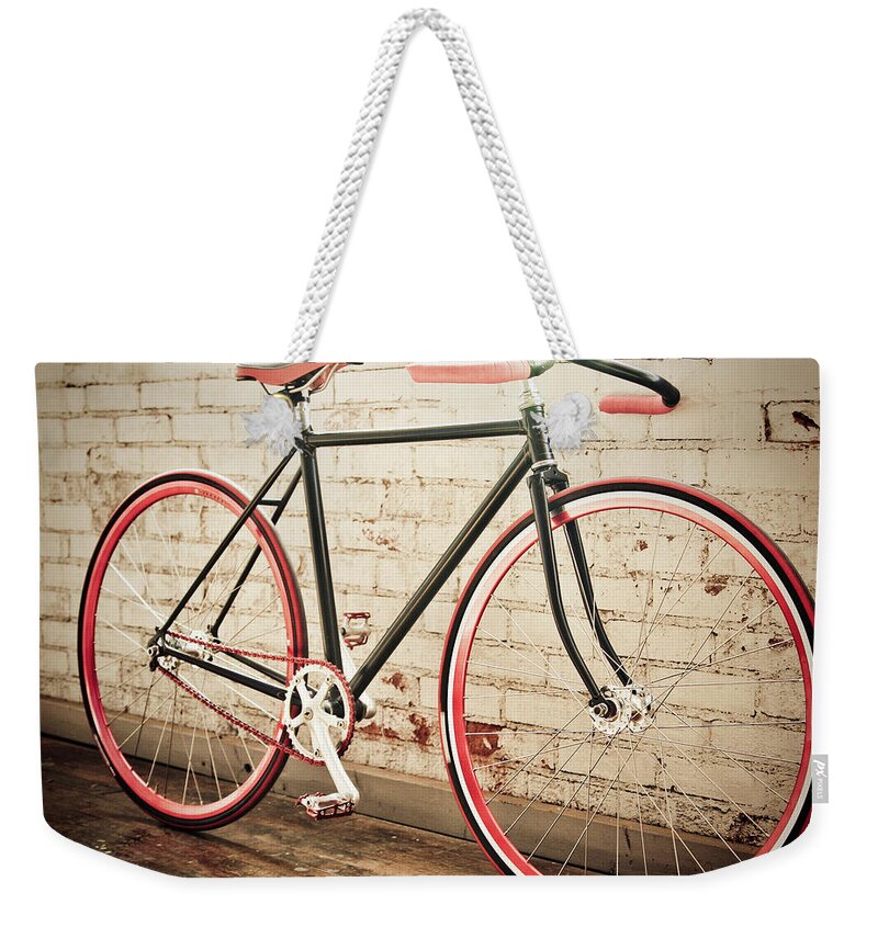 Michigan Weekender Tote Bag featuring the photograph Red Bicycle Leaning Against Brick Wall by Rudy Malmquist