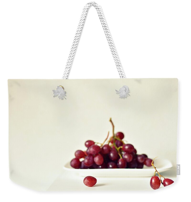 White Background Weekender Tote Bag featuring the photograph Red Grapes On White Plate by Photo By Ira Heuvelman-dobrolyubova
