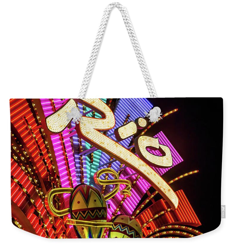 The Rio Weekender Tote Bag featuring the photograph Rio Casino Sign at Night low Angle from the North West by Aloha Art
