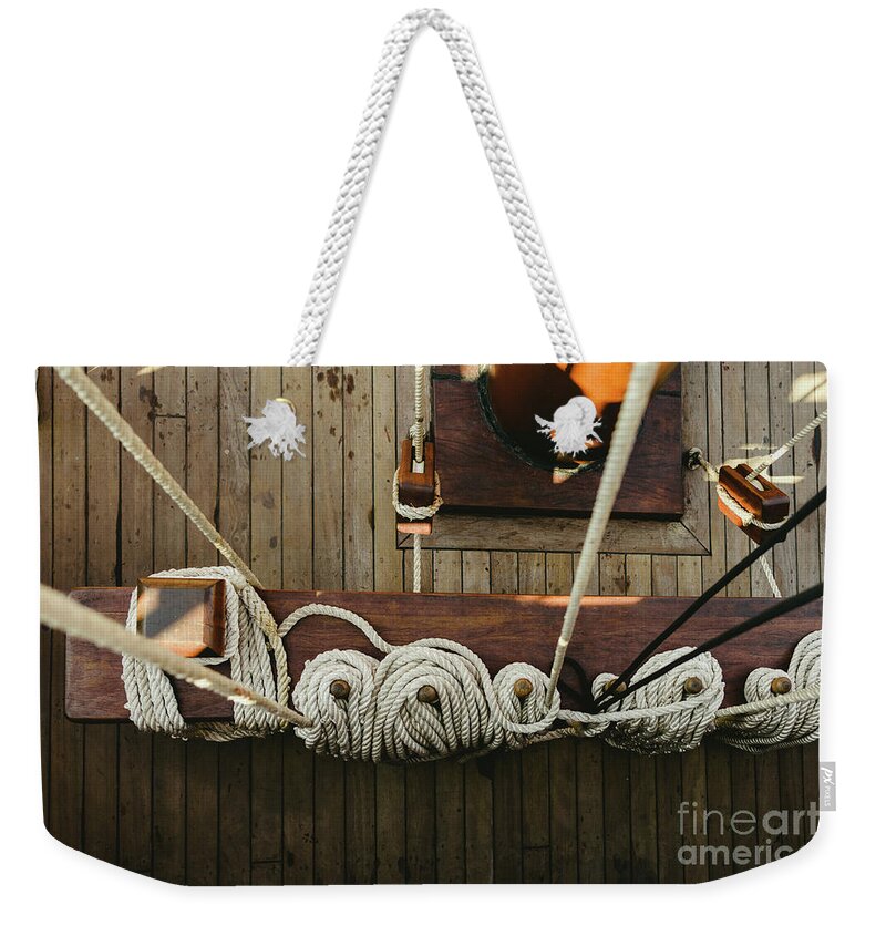 Abstract Weekender Tote Bag featuring the photograph Ropes to hold the sails of an old sailboat rolled. by Joaquin Corbalan
