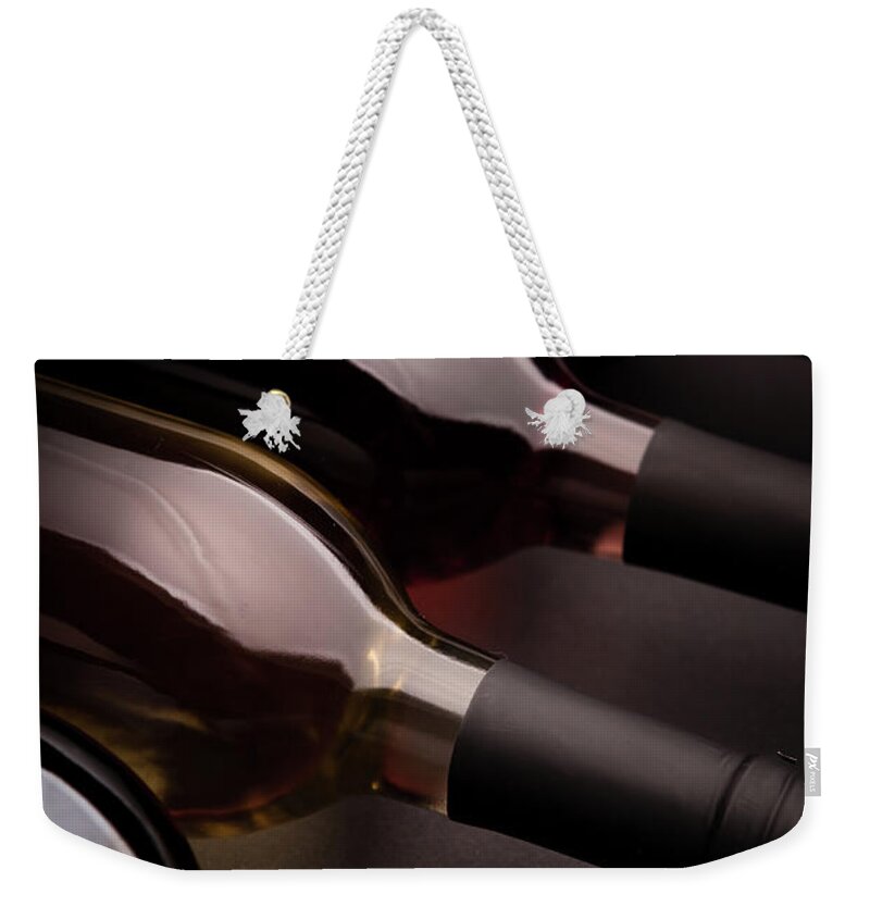 Alcohol Weekender Tote Bag featuring the photograph Row Of Wine Bottles by Halbergman