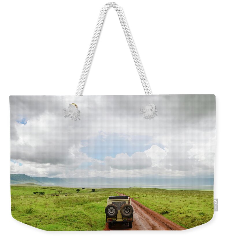 Grass Weekender Tote Bag featuring the photograph Safari Vehicle W Tourists In Ngorongoro by Volanthevist