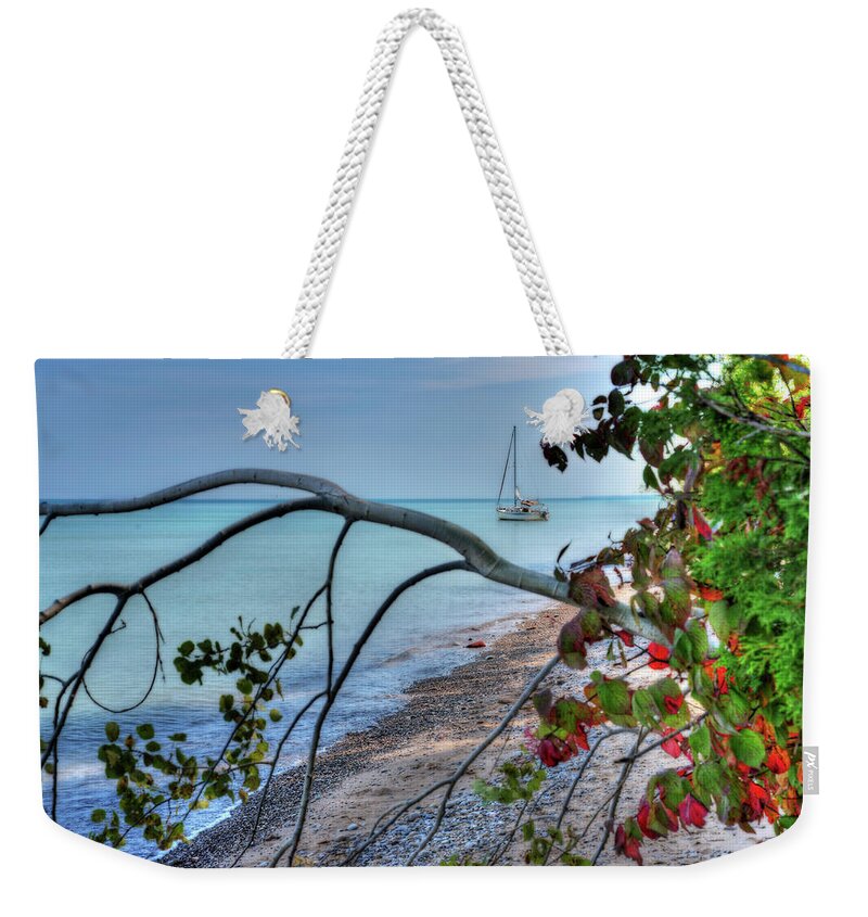 Sailboat Sailing Boat Autumn Red Leaves Lake Michigan Milwaukee Wi Wisconsin Great Lakes Aqua Turquoise Weekender Tote Bag featuring the photograph Sailboat Serenity - Sailboat anchored in Lake Michigannear Shorewood Nature Preserve in Milwaukee WI by Peter Herman