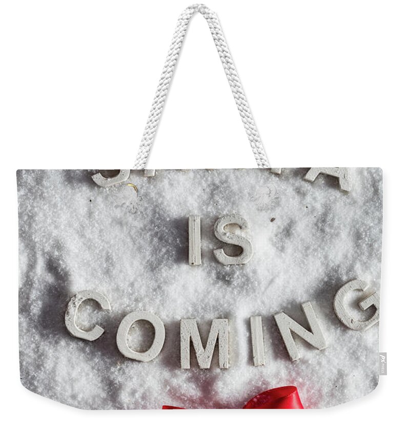 Christmas Weekender Tote Bag featuring the photograph SANTA IS COMING writing and a red bow by Michal Bednarek