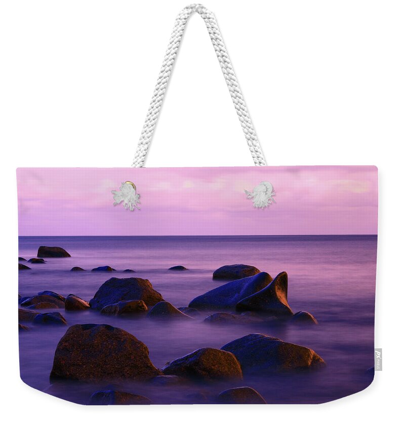 Water's Edge Weekender Tote Bag featuring the photograph Seascape With Some Rocks Protruding The by Imaginegolf