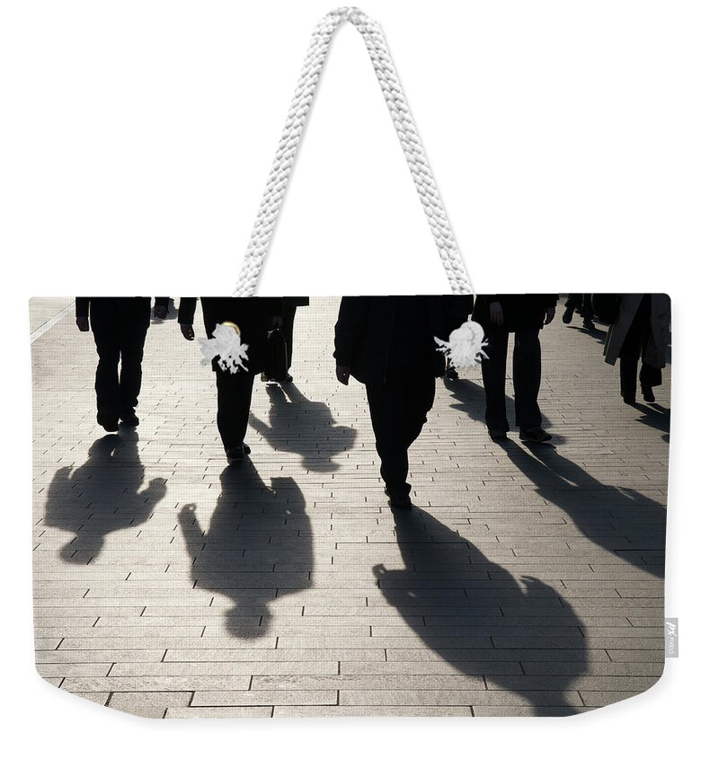 Shadow Weekender Tote Bag featuring the photograph Shadow Team Of Commuters Walking On by Peskymonkey