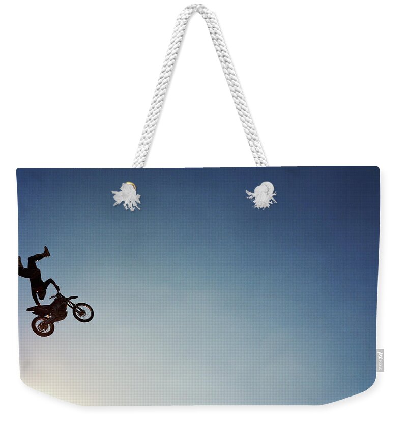 Crash Helmet Weekender Tote Bag featuring the photograph Silhouette Of Man Performing Stunts On by Andy Ryan