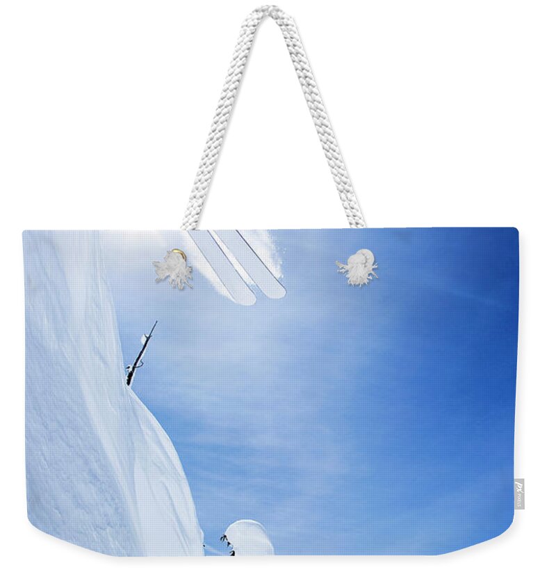 Ski Pole Weekender Tote Bag featuring the photograph Skier Jumping On Snowy Slope by Jakob Helbig