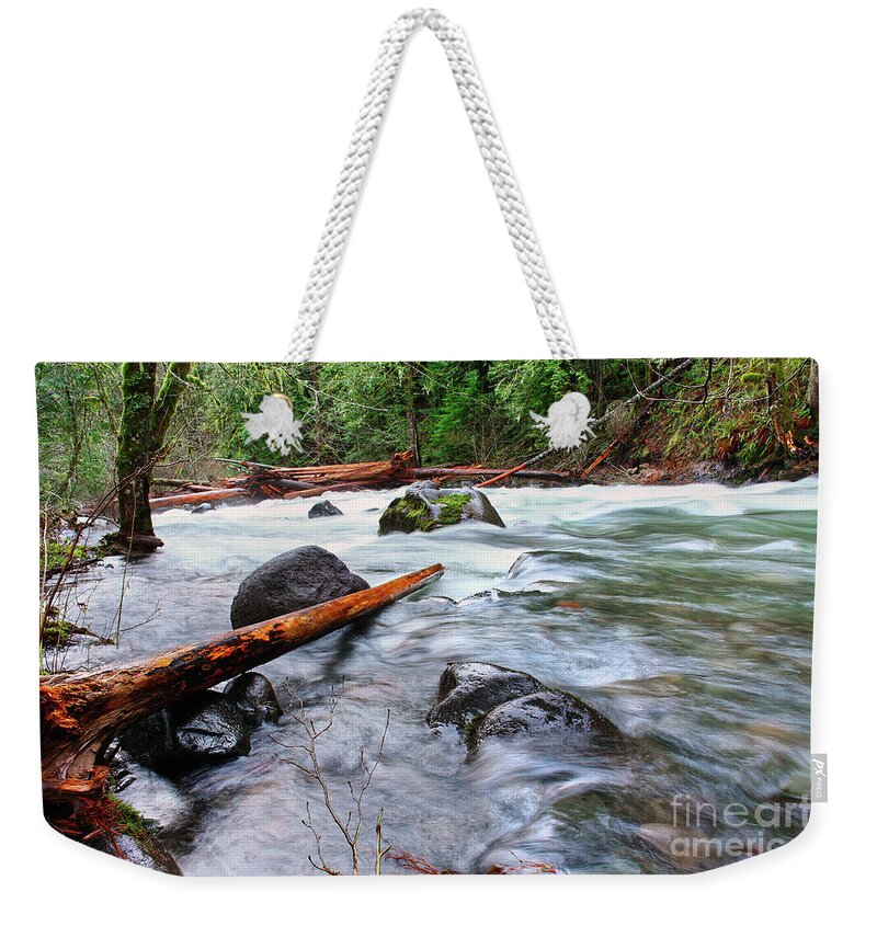 Flooded River Creek Weekender Tote Bag featuring the photograph smooth fast flowing Roaring River storm level high water flowing over banks logs lining riverbanks by Robert C Paulson Jr