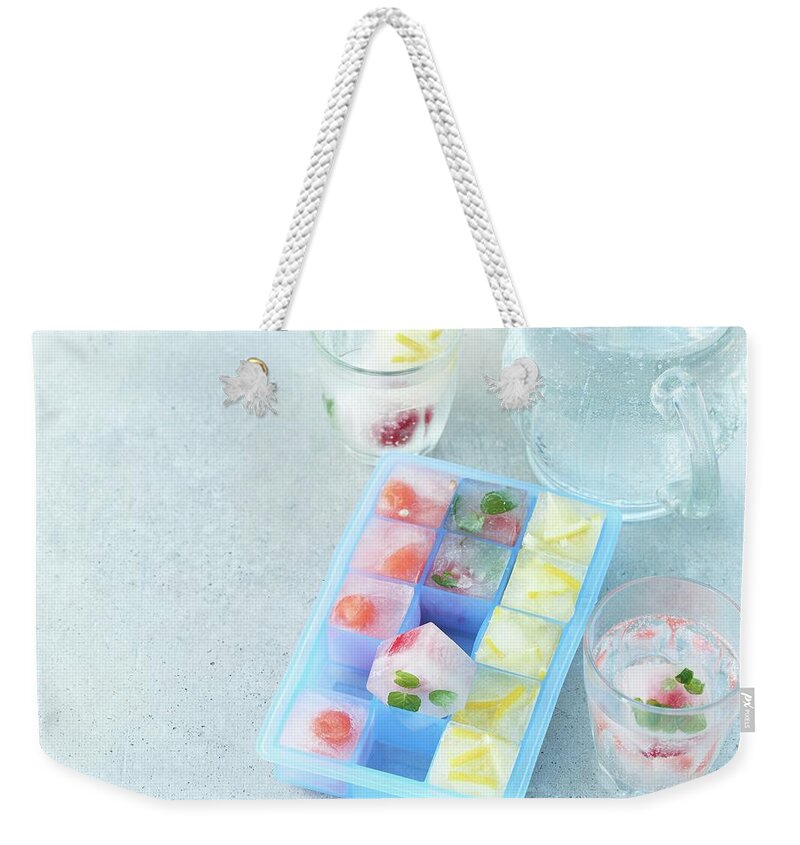 Ip_12338011 Weekender Tote Bag featuring the photograph Summer Fruit Ice Cubes In An Ice Cube Tray And In Glasses by Stefan Schulte-ladbeck