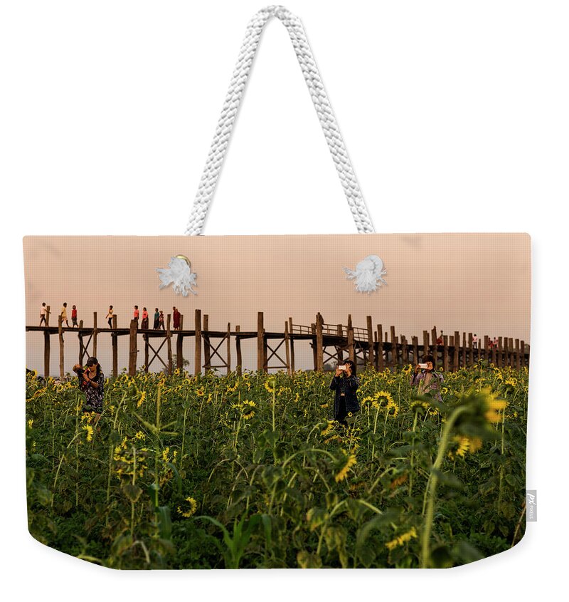 People Weekender Tote Bag featuring the photograph Sunflower Field Below U Bein Bridge by Merten Snijders