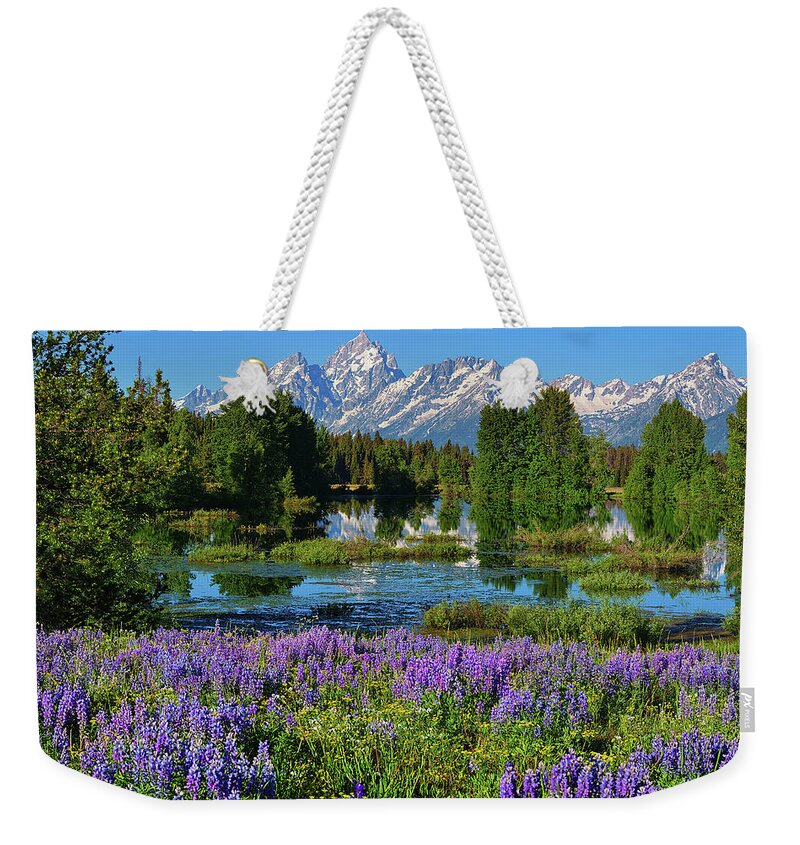 Grand Teton National Park Weekender Tote Bag featuring the photograph Tetons and Lupines by Greg Norrell