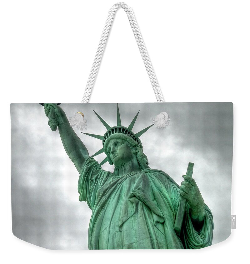 Statue Weekender Tote Bag featuring the photograph The Statue Of Liberty Nyc Under A by Marcel Germain