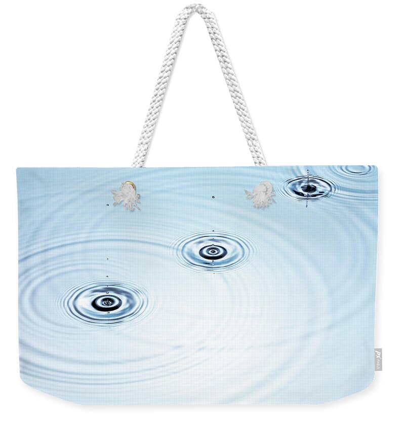 Purity Weekender Tote Bag featuring the photograph Three Drops Of Water Falling Into A by Pier