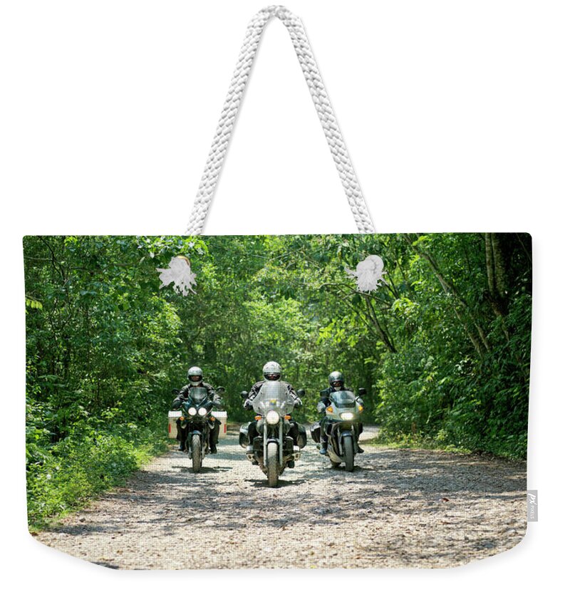 Crash Helmet Weekender Tote Bag featuring the photograph Three Men Riding Motorbikes Along by Xpacifica