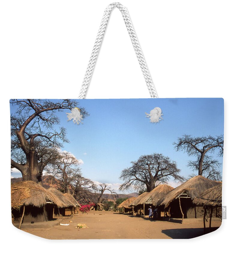Tranquility Weekender Tote Bag featuring the photograph Traditional Thatched Houses And Baobabs by © Santiago Urquijo