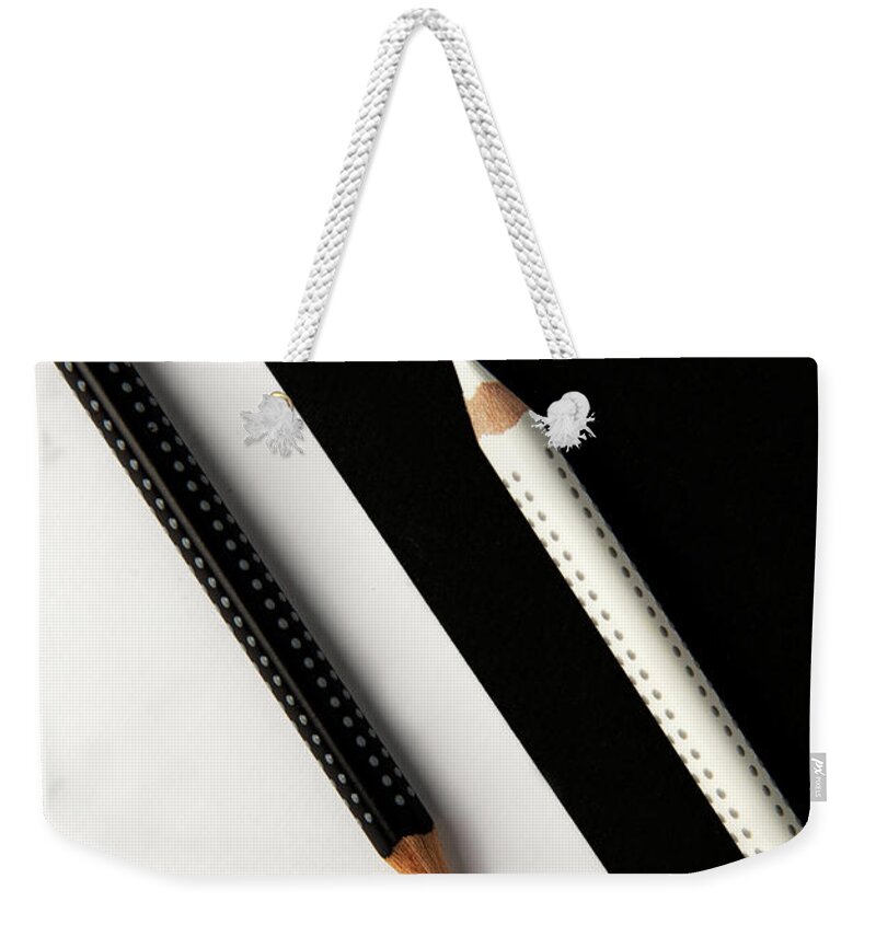 Pencil Weekender Tote Bag featuring the photograph Two drawing pencils on a black and white surface. by Michalakis Ppalis