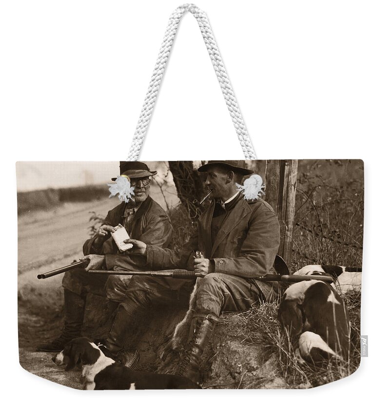 Pets Weekender Tote Bag featuring the photograph Two Hunters With Dogs Sharing Cigars by Fpg