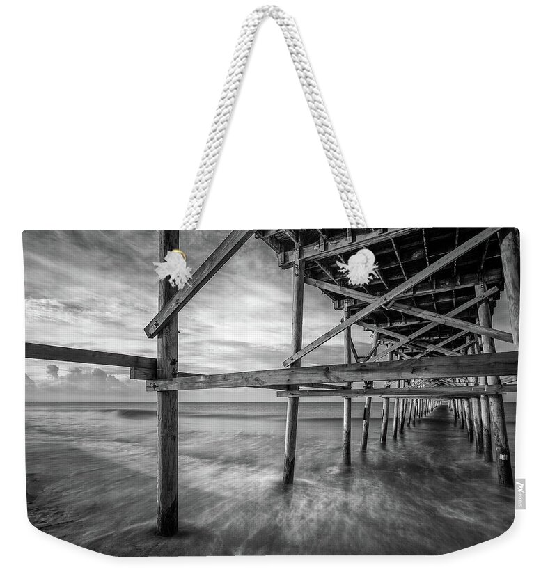Oak Island Weekender Tote Bag featuring the photograph Uner the Pier in Black and White by Nick Noble