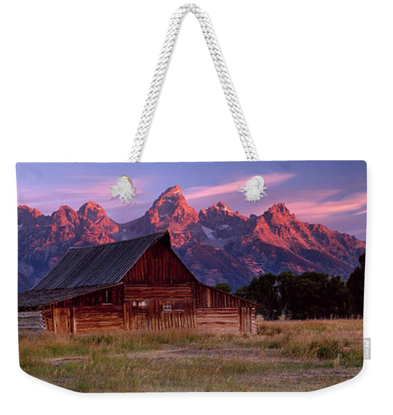 Scenics Weekender Tote Bag featuring the photograph Weathered Wooden Barn With Mountains by Travelpix Ltd