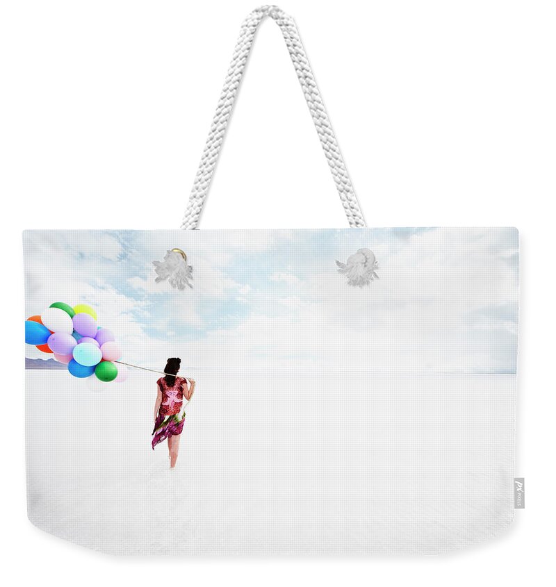Scenics Weekender Tote Bag featuring the photograph Woman Holding Balloons Walking Through by Thomas Barwick