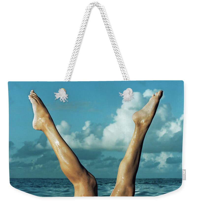 Diving Into Water Weekender Tote Bag featuring the photograph Woman Stretching Legs From Water by Matthias Clamer