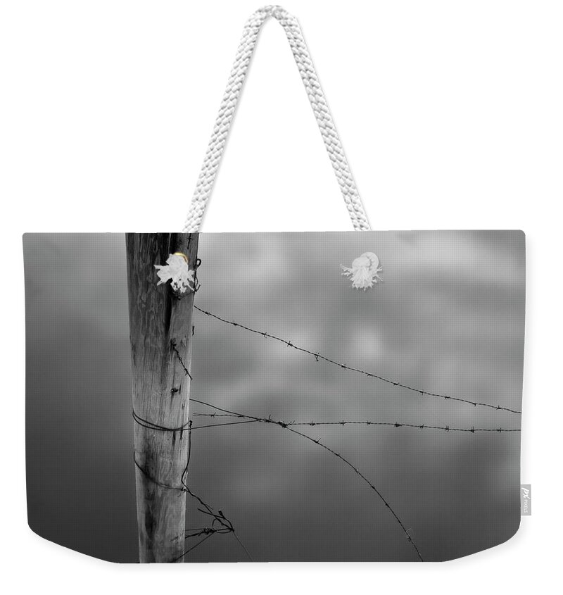 Wooden Post Weekender Tote Bag featuring the photograph Wooden Post With Barbed Wire by Peter Levi