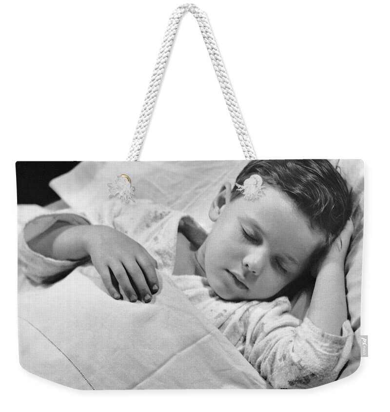 Child Weekender Tote Bag featuring the photograph Young Boy Asleep In Bed by George Marks