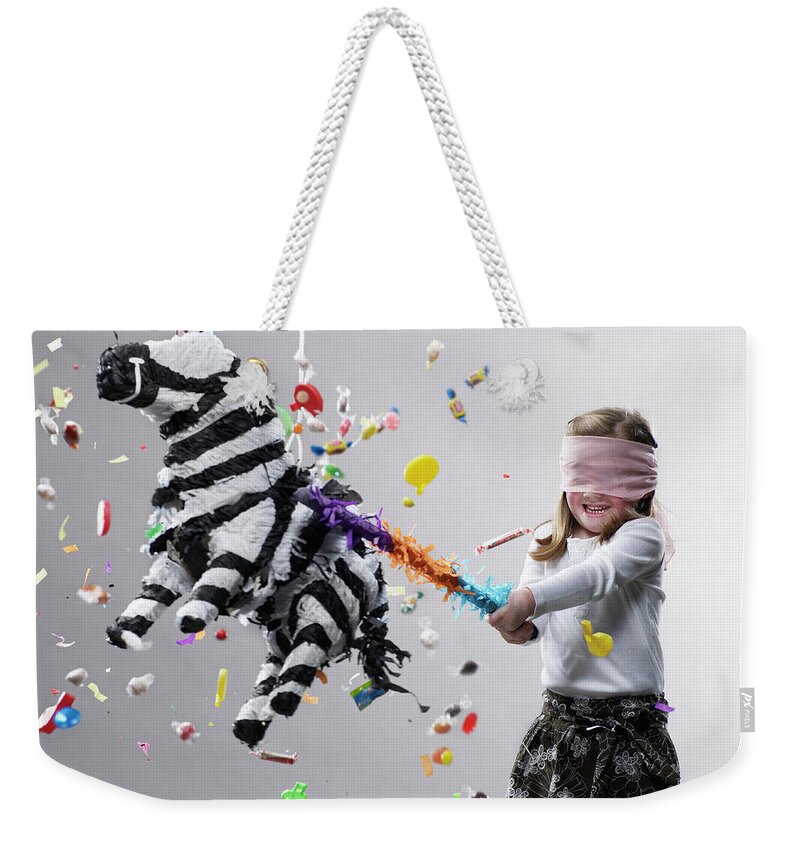 4-5 Years Weekender Tote Bag featuring the photograph Young Girl Hitting Pinata, Candy Flying by Ryan Mcvay