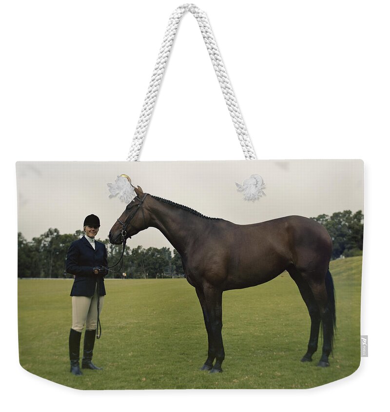 People Weekender Tote Bag featuring the photograph Young With Horse Standing On Field by Tom Kelley Archive